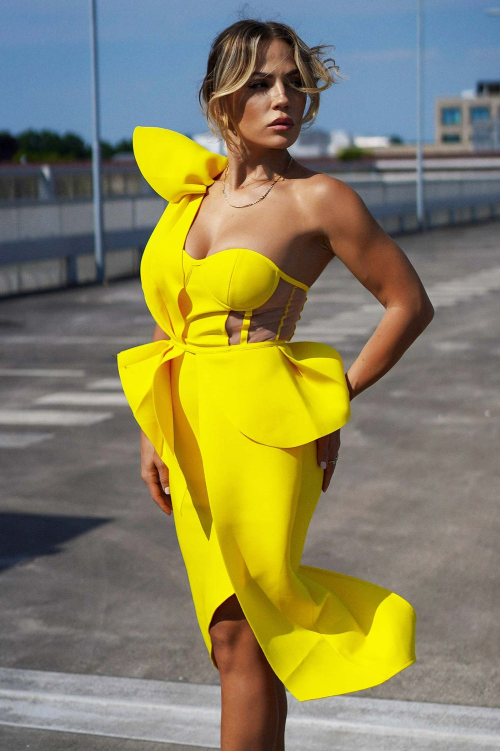 Tek omuzlu sarı kokteyl midi elbise, düzensiz etek kesimi ve bel vurgusu.