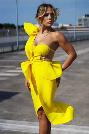 Tek omuzlu sarı kokteyl midi elbise, düzensiz etek kesimi ve bel vurgusu.