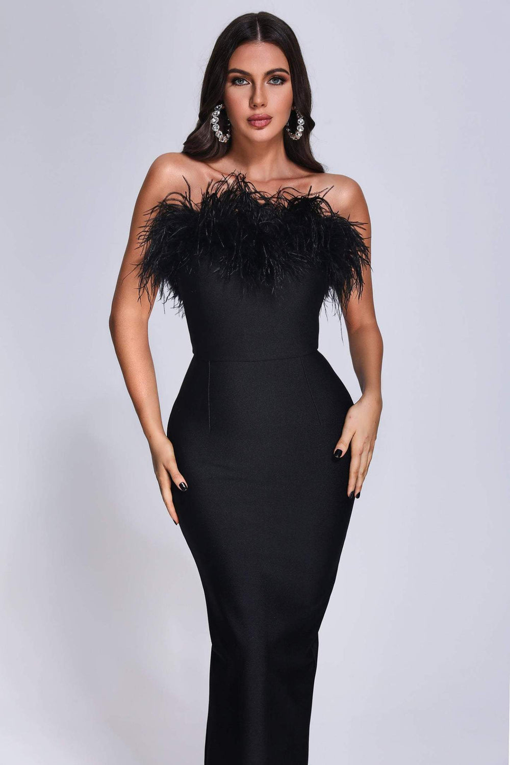 Strapless black bandage dress with feather-adorned neckline and bodycon maxi skirt.